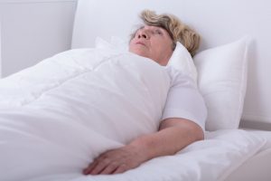 lady lying completely flat in bed
